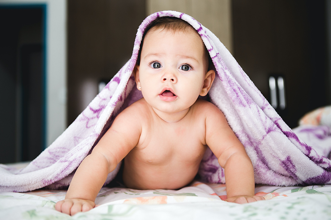 Cute baby with blanket on its head